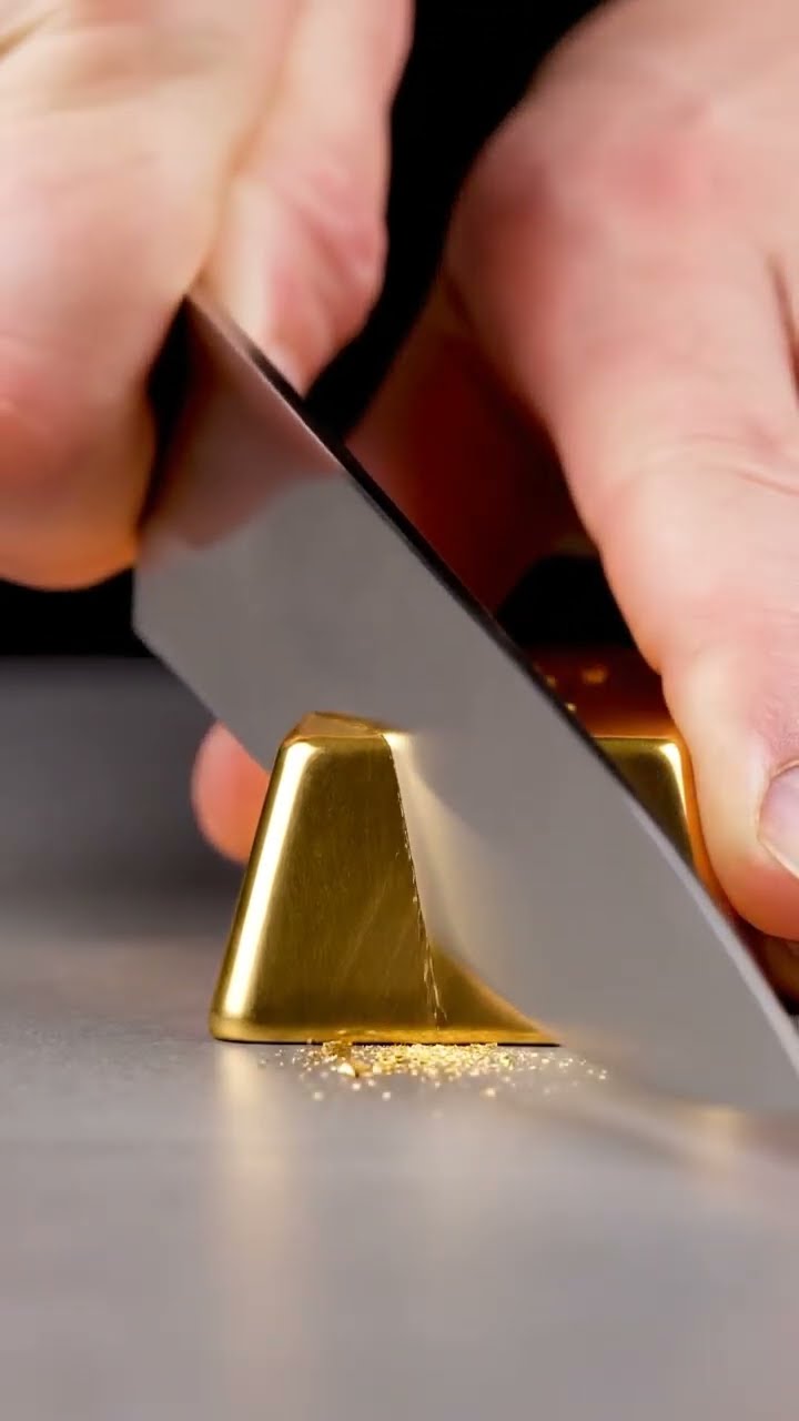 AI-generated ASMR video frame: Gleaming gold bar, slow chef’s-knife cut